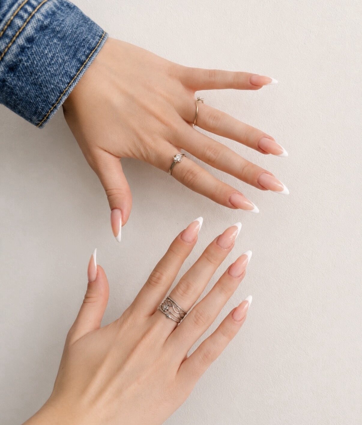 French blanche sur ongles amande longs, sur fond crème.